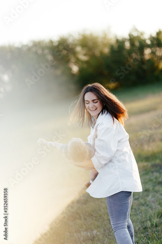 Young mother playing with her son in nature