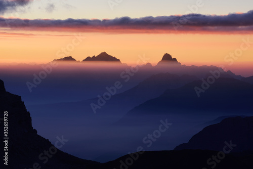 High peaks of mountains shrouded in morning mist.