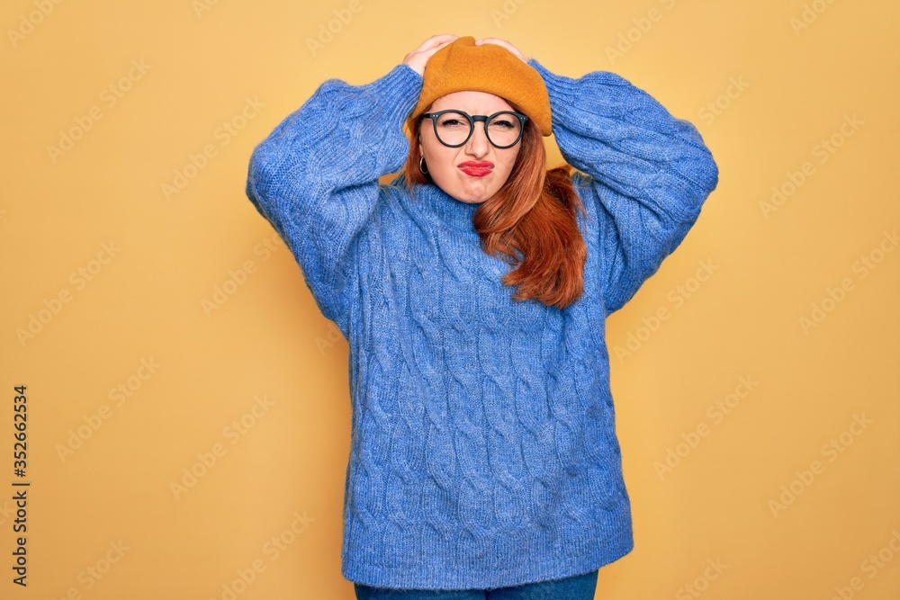 Young beautiful redhead woman wearing french beret and glasses over yellow background suffering from headache desperate and stressed because pain and migraine. Hands on head. Young beautiful redhead woman wearing french beret and glasses over yellow background suffering from headache desperate and stressed because pain and migraine. Hands on head.
