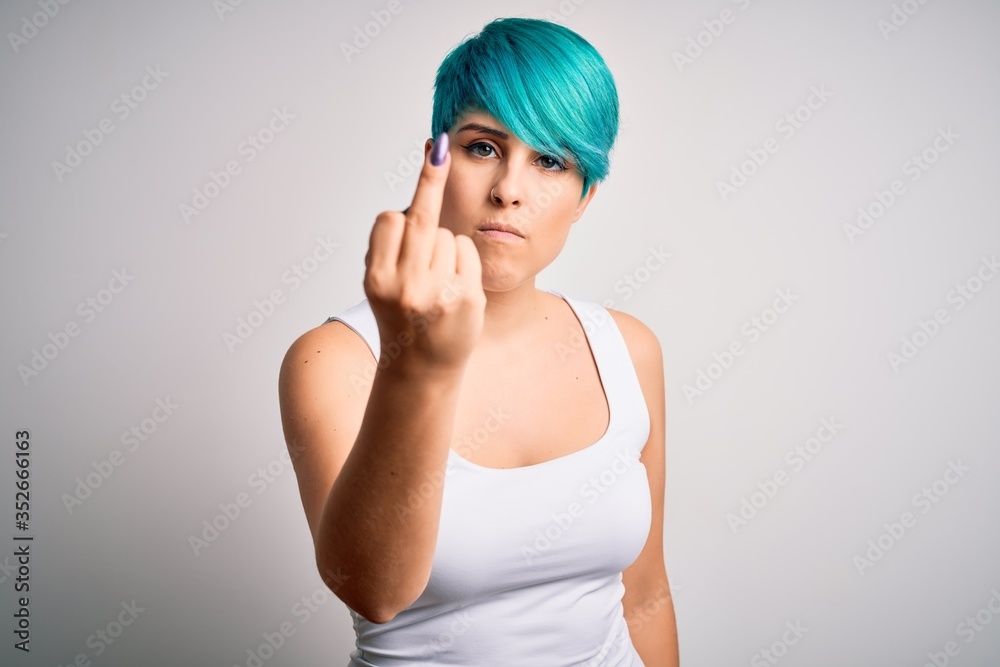 Young beautiful woman with blue fashion hair wearing casual t-shirt over white background Showing middle finger, impolite and rude fuck off expression Young beautiful woman with blue fashion hair wearing casual t-shirt over white background Showing middle finger, impolite and rude fuck off expression