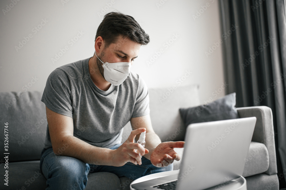 Young man with medical mask working home online at quarantine Young man with medical mask working home online at quarantine