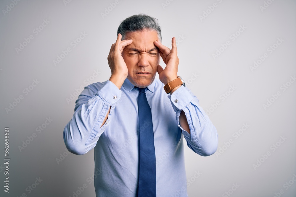 Middle age handsome grey-haired business man wearing elegant shirt and tie with hand on headache because stress. Suffering migraine. Middle age handsome grey-haired business man wearing elegant shirt and tie with hand on headache because stress. Suffering migraine.