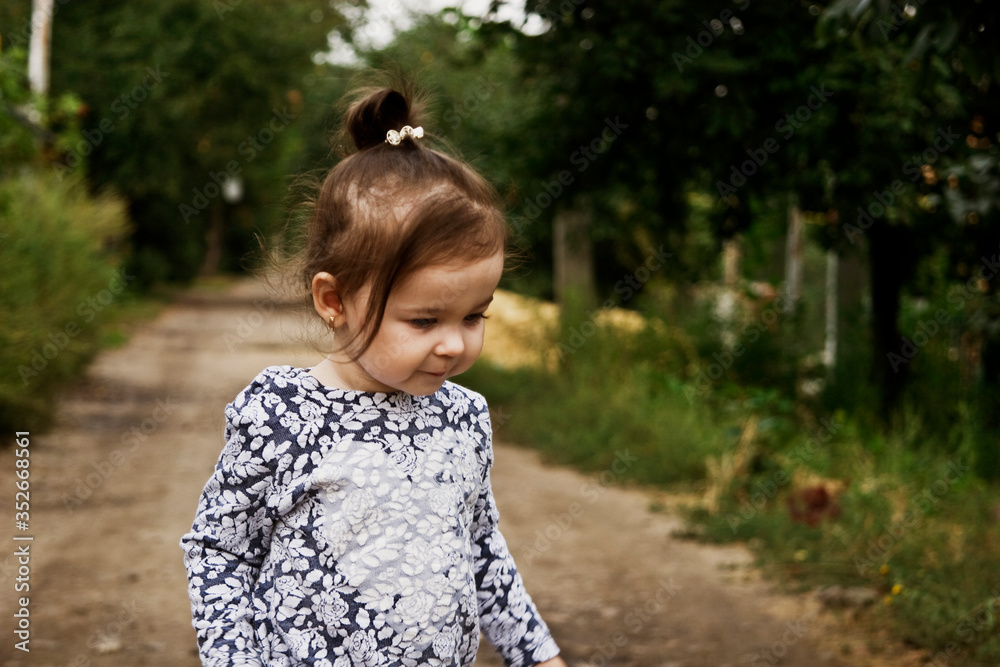 Little beautiful girl walks along the road. Baby portrait photo close-up. Cute baby is spending time carefree. Beautiful little girl walks along the road. A child with beautiful eyes. Children. Child Little beautiful girl walks along the road. Baby portrait photo close-up. Cute baby is spending time carefree. Beautiful little girl walks along the road. A child with beautiful eyes. Children. Child