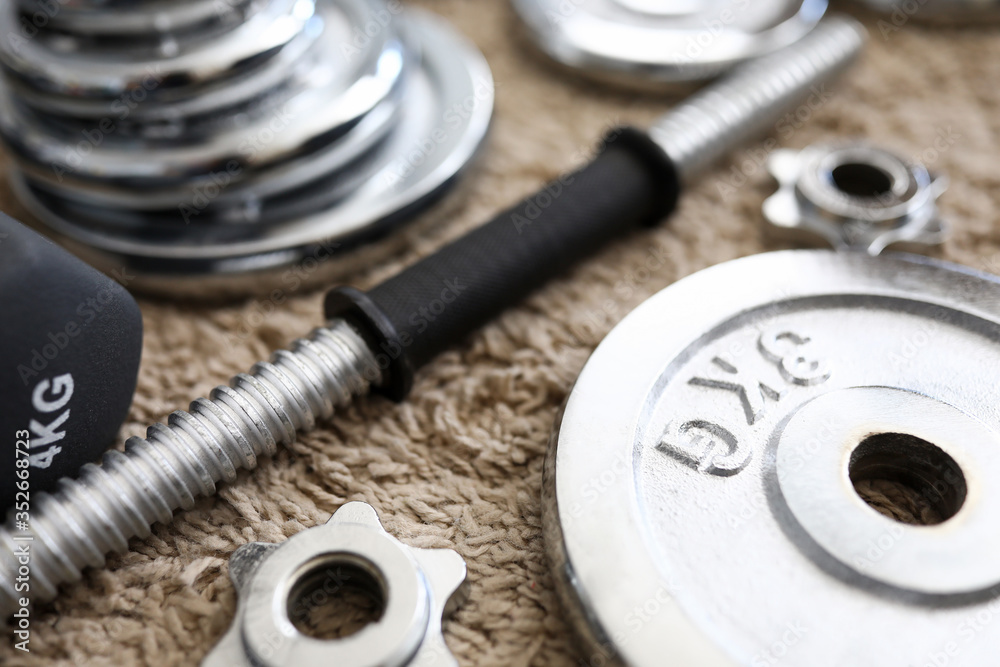 Pile of shiny chrome dumbbells disks lying around grip Pile of shiny chrome dumbbells disks lying around grip