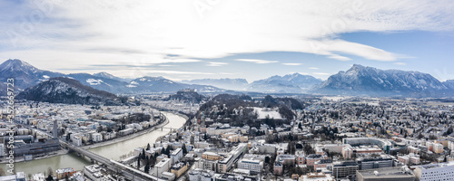 Panoramic aerial drone view of Salzburg snowy old town with view of Hohensalzburg fortress Unesberg in winter morning
