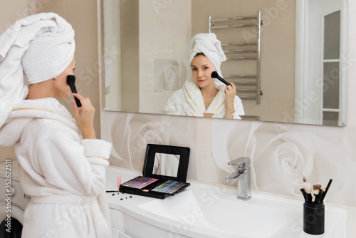 Woman doing herself makeup at home in the bathroom