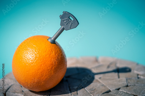 Canvas Print A Clockwork Orange : an orange fruit with a key inside pill on a wooden table