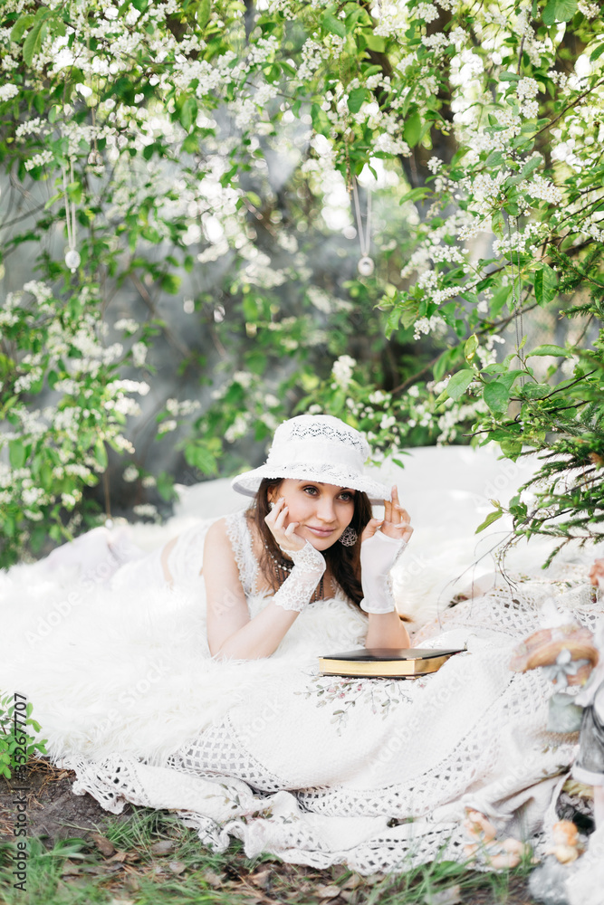 Tender girl in a white dress in the flowers of bird cherry Tender girl in a white dress in the flowers of bird cherry