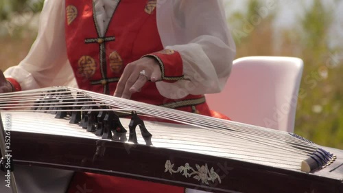 A woman in a national costume plays the Buryat national string instrument