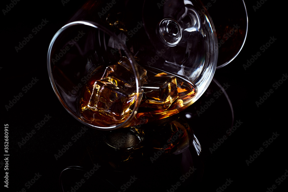 Snifter glass with cognac (brandy snifter, brandy bowl, cognac glass, or balloon) lying on a
