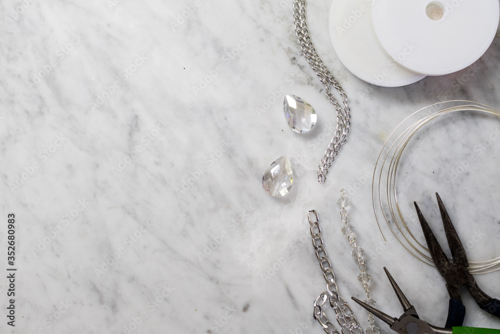 Bijoux flatlay with crafting elements on a white marble table Bijoux flatlay with crafting elements on a white marble table