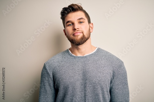 Young handsome blond man with beard and blue eyes wearing casual sweater Relaxed with serious expression on face. Simple and natural looking at the camera. © Krakenimages.com