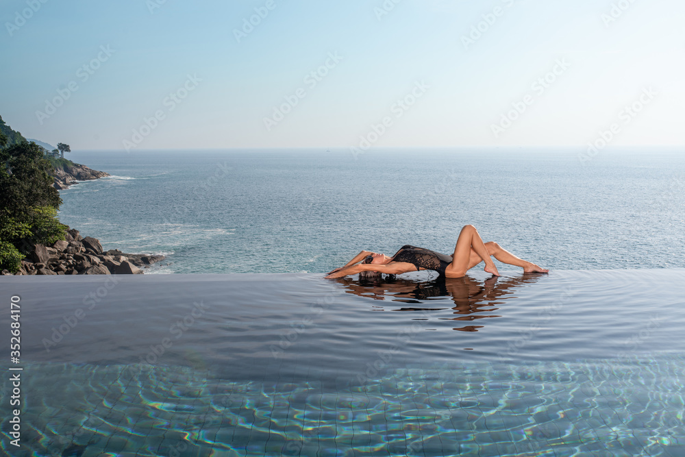 woman lie in infinity pool at sunrise