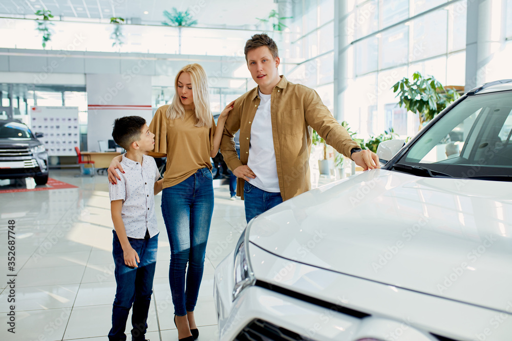 i want this one, young family is considering buying a new car in dealership, they choose and look at auto design i want this one, young family is considering buying a new car in dealership, they choose and look at auto design