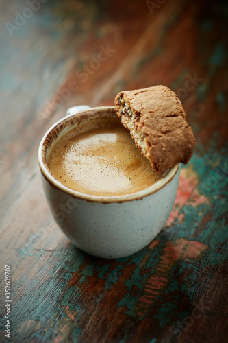 Cup of coffee with cantuccini (Italian cookies) on rustic wooden background.