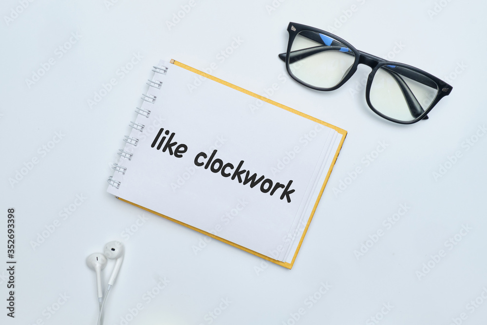 Like clockwork - english idiom hand lettering on wooden blocks Like clockwork - english idiom hand lettering on wooden blocks