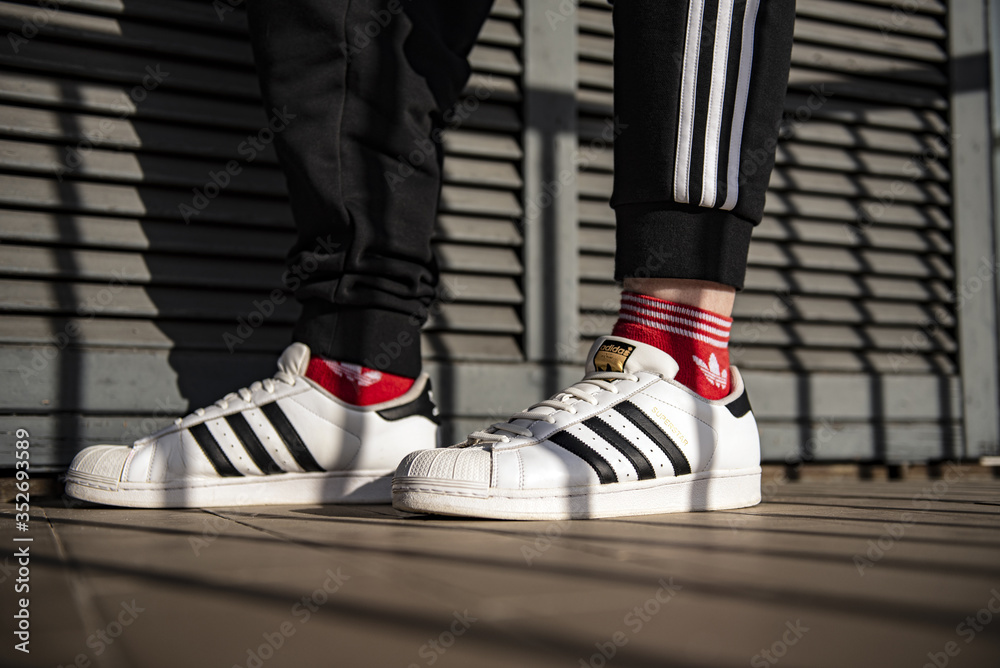 Young man wearing Adidas Superstar Stock Photo | Adobe Stock