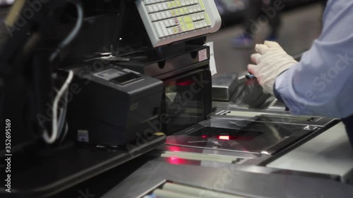 Close up shot of cashier scanning food at checkout counter. Buying meal in a supermarket Cashier in protective rubber gloves. Purchasing goods during lockdown