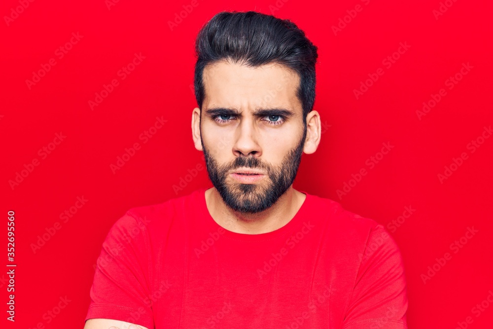 Young handsome man with beard wearing casual t-shirt skeptic and nervous, disapproving expression on face with crossed arms. negative person. Young handsome man with beard wearing casual t-shirt skeptic and nervous, disapproving expression on face with crossed arms. negative person.
