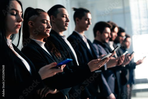 young business people with smartphones standing in line