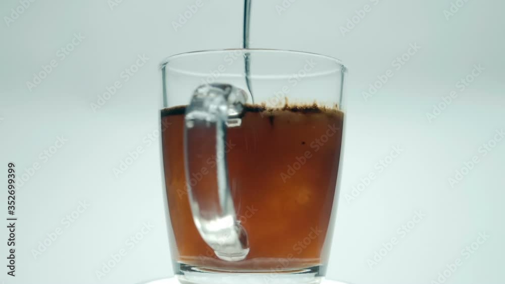 Stir the granulated coffee particles in hot water by a spoon, on a