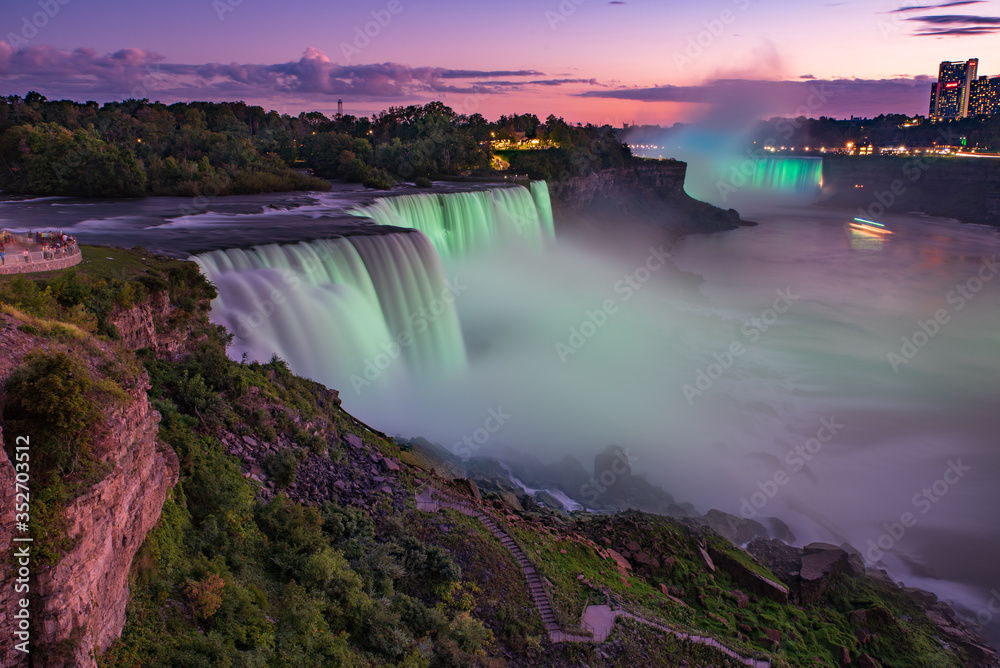 Illuminated Niagara falls at sunset, Buffalo NY. American Falls illuminated by the light from Canadian side. 