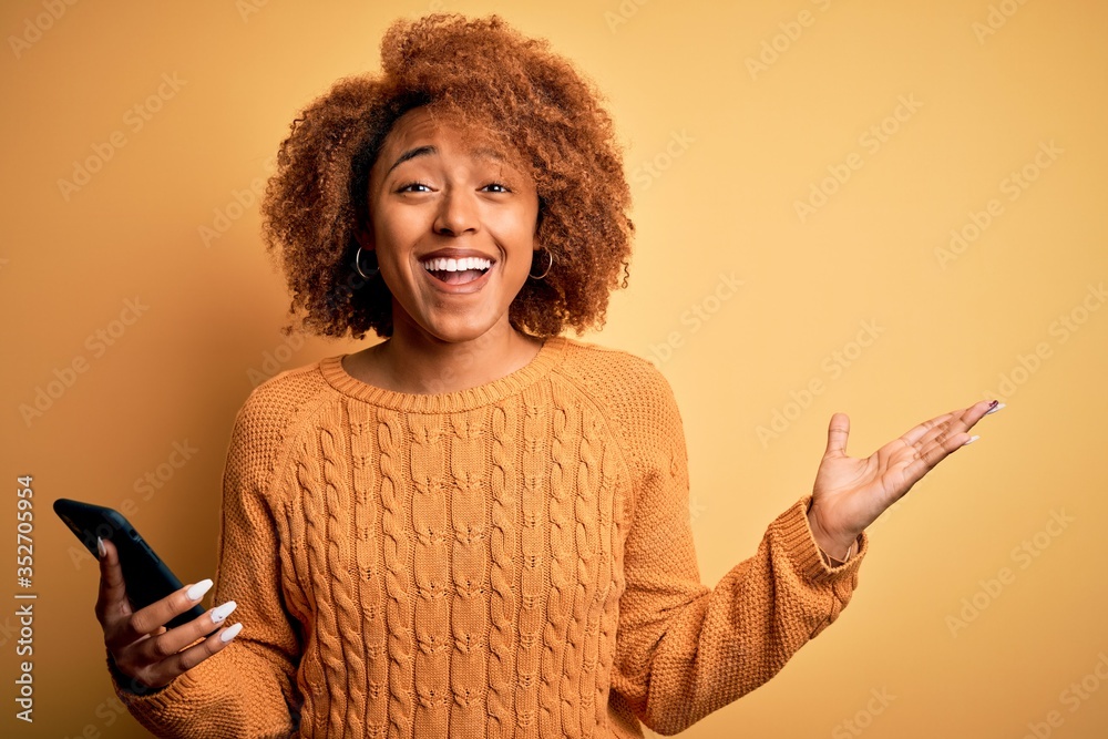 Young African American afro woman with curly hair having conversation using smartphone very happy and excited, winner expression celebrating victory screaming with big smile and raised hands Young African American afro woman with curly hair having conversation using smartphone very happy and excited, winner expression celebrating victory screaming with big smile and raised hands