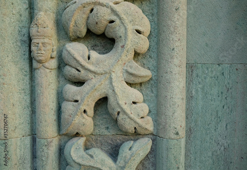 Beutiful floral stone relief with a leaf and a small head.