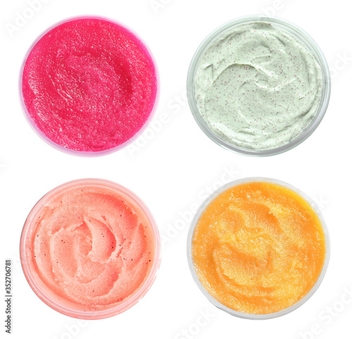 Set of containers with different natural scrubs on white background, top view