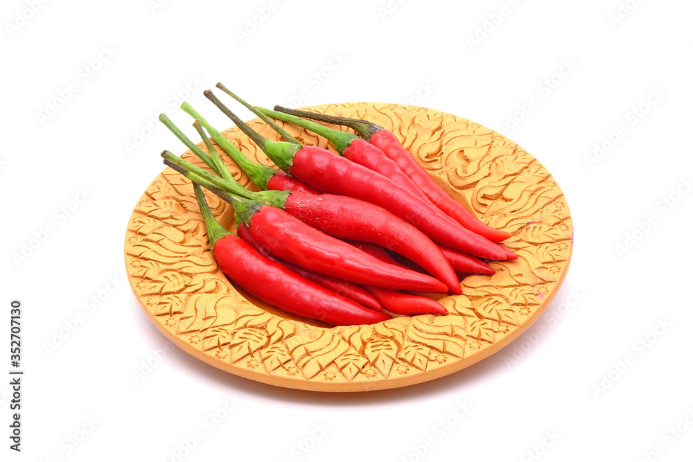 Red hot chili peppers on Thai style clay dish isolated on white background. Selective focus Red hot chili peppers on Thai style clay dish isolated on white background. Selective focus