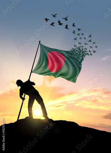 Canvas Print Bangladesh flag turn to birds while being planted by a man on a hill during sunrise