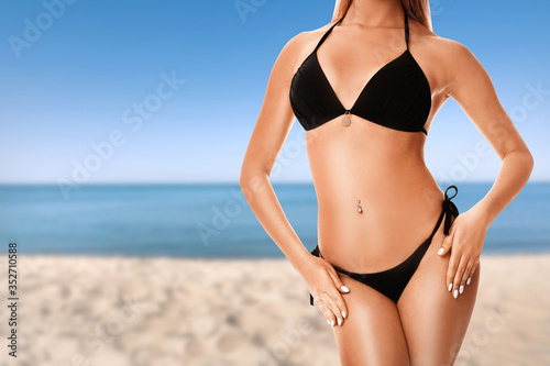 Young woman with smooth silky skin after epilation on beach, closeup. Space for text