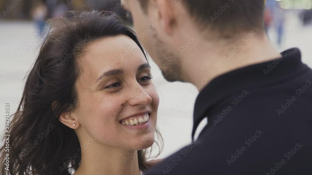 Portrait of attractive couple standing at the city street talking and smiling Portrait of attractive couple standing at the city street talking and smiling