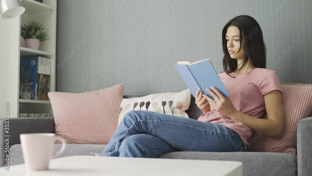 Woman reading a book and realxing on sofa at home Woman reading a book and realxing on sofa at home