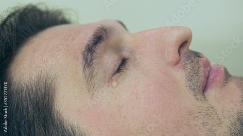 High quality close-up of a man laying on a couch and crying during the treatment. Male tears closeup video.