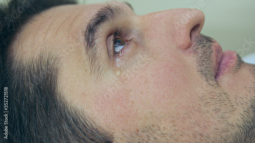 High quality close-up of a man laying on a couch and crying during the treatment. Male tears closeup video.