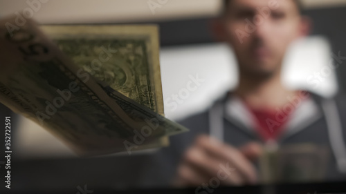 High quality slow motion close-up of a young man counting american dollars cash and coins. US money, financial crisis and lockdown. Salary in america.