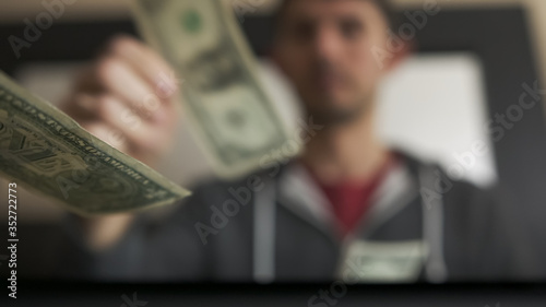 High quality slow motion close-up of a young man counting american dollars cash and coins. US money, financial crisis and lockdown. Salary in america.