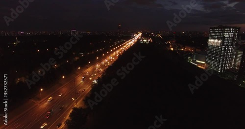 4K early night aerial video of busy road traffic with background view of high-rise buildings and memorial complex in Moscow, Russia