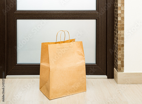 Paper bag near door of house. Safe delivery concept. Contactless home food delivery. Precautionary measures.