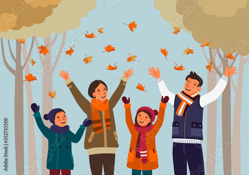 Happy family having fun and playing with autumn leaves in park. Autumn landscape background