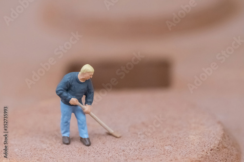 Miniature people cleaning the floor