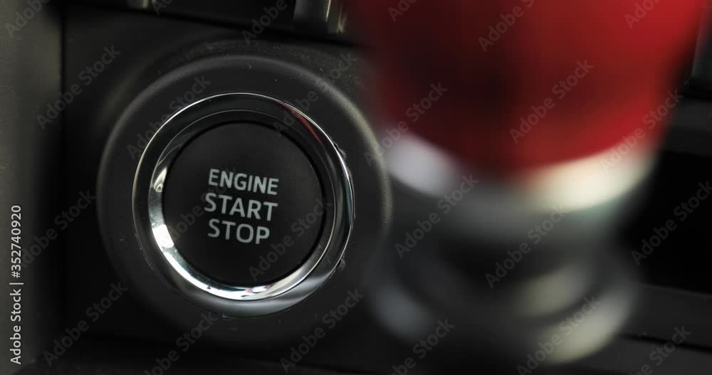 Man is pressing the button engine start stop in car, finger closeup. The driver is driving a car. Preparing to start or stop auto inside it.