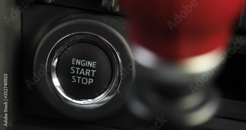 Man is pressing the button engine start stop in car, finger closeup. The driver is driving a car. Preparing to start or stop auto inside it.
