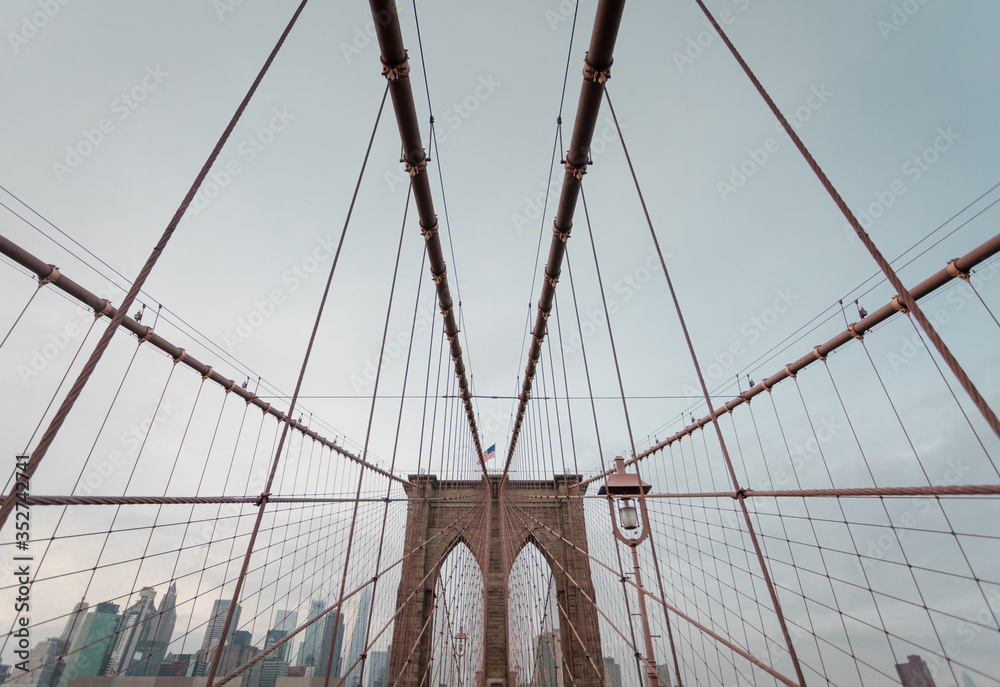 Fototapeta premium Symmetric View of Brooklyn Bridge in New York City, moody Style, on a cloudy Day