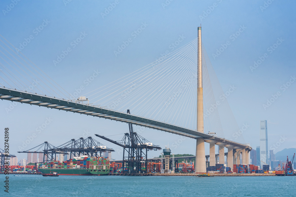 Cargo port and bridge in harbor of Hong Kong city