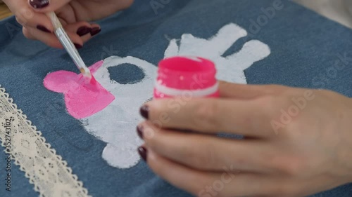Designer painting on denim cloth. Making personal collection dresses for girls