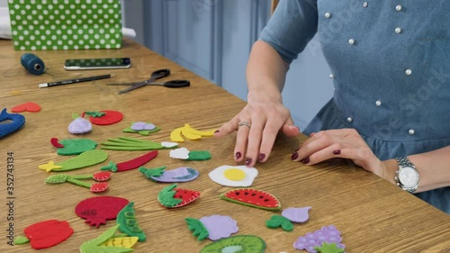 Designer makes, sews soft childrens toys from fabric. In the form of fruits