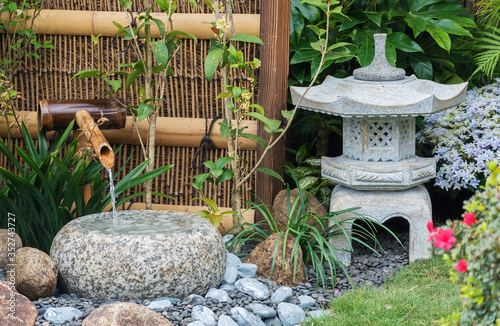 Canvas Print stone lantern and bamboo fountain in Japanese garden