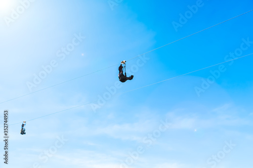 Motion blur and soft focus of Extreme sportsman jumps on a rope with bright sunlight clear blue sky background.